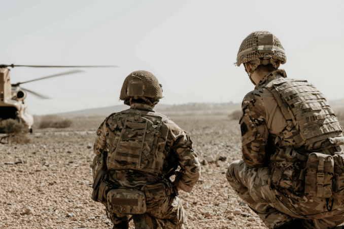 Soldados de las Fuerzas Armadas británicas agachados ante un helicóptero